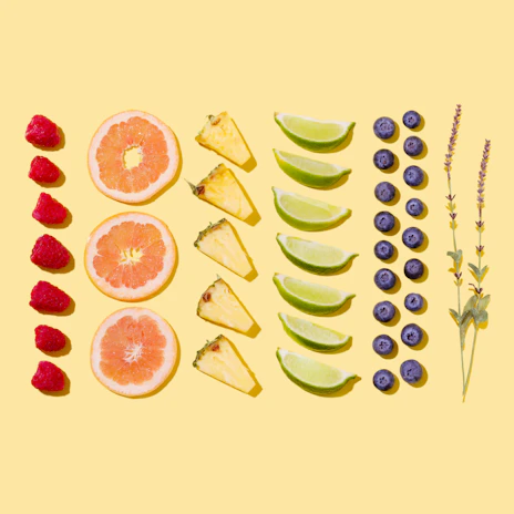 A close-up of fresh, colorful fruits and herbs arranged on a wooden table.