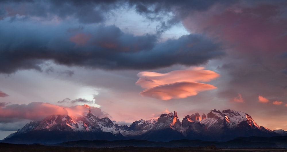 montagna innevata sotto il cielo nuvoloso durante il giorno