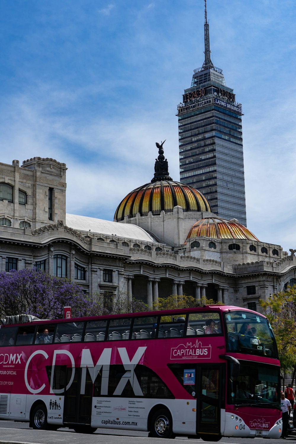 red bus near brown concrete building during daytime