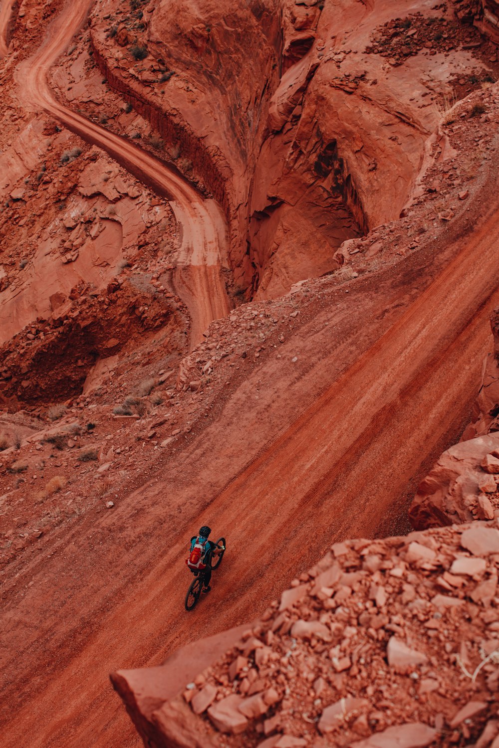 man in black jacket and blue denim jeans riding motorcycle on brown rock formation during daytime