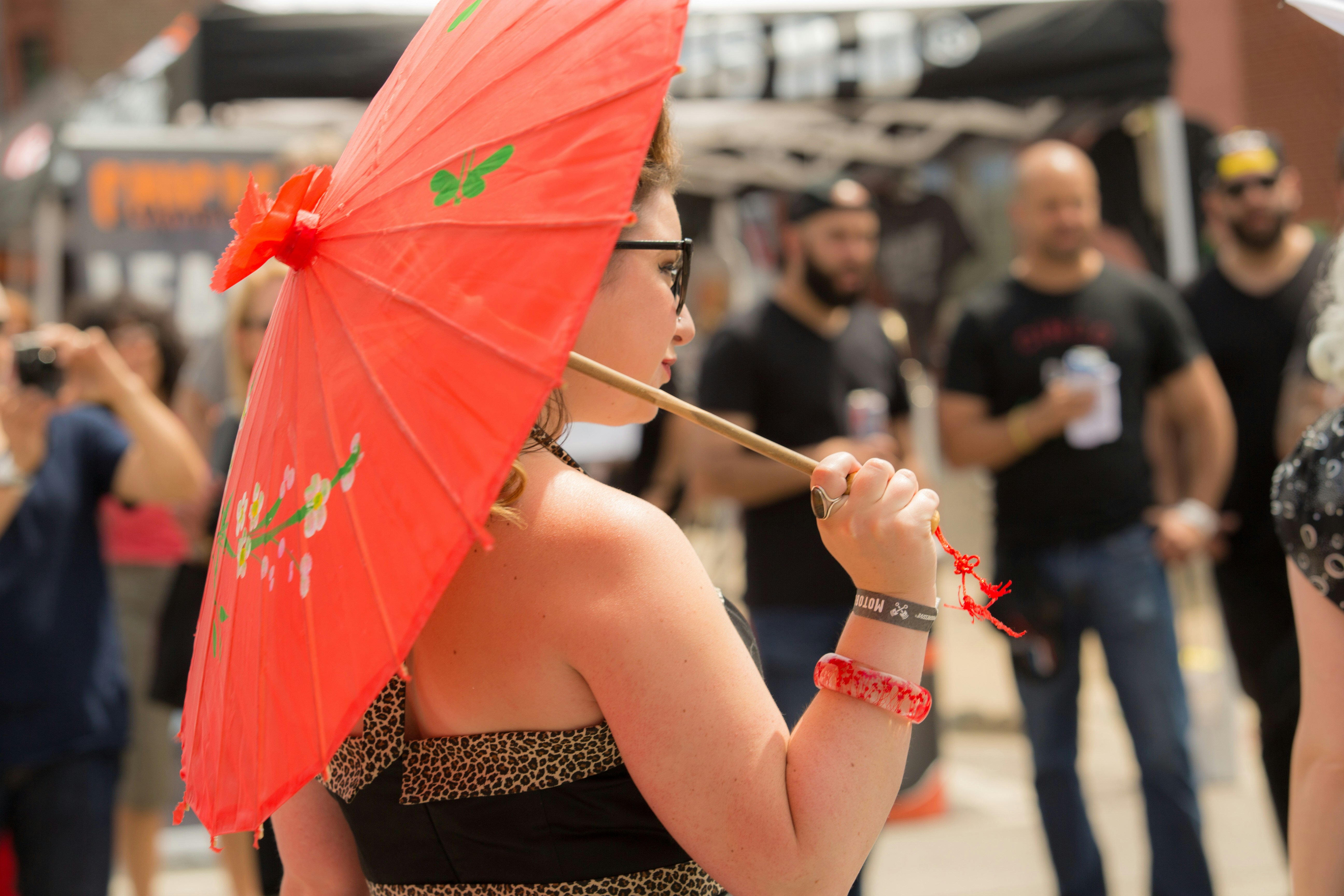 woman in black tube dress holding red umbrella