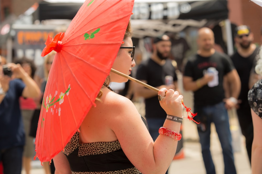 woman in black tube dress holding red umbrella