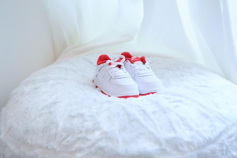 Weiße und rote Nike Sneakers auf weißem Textil
