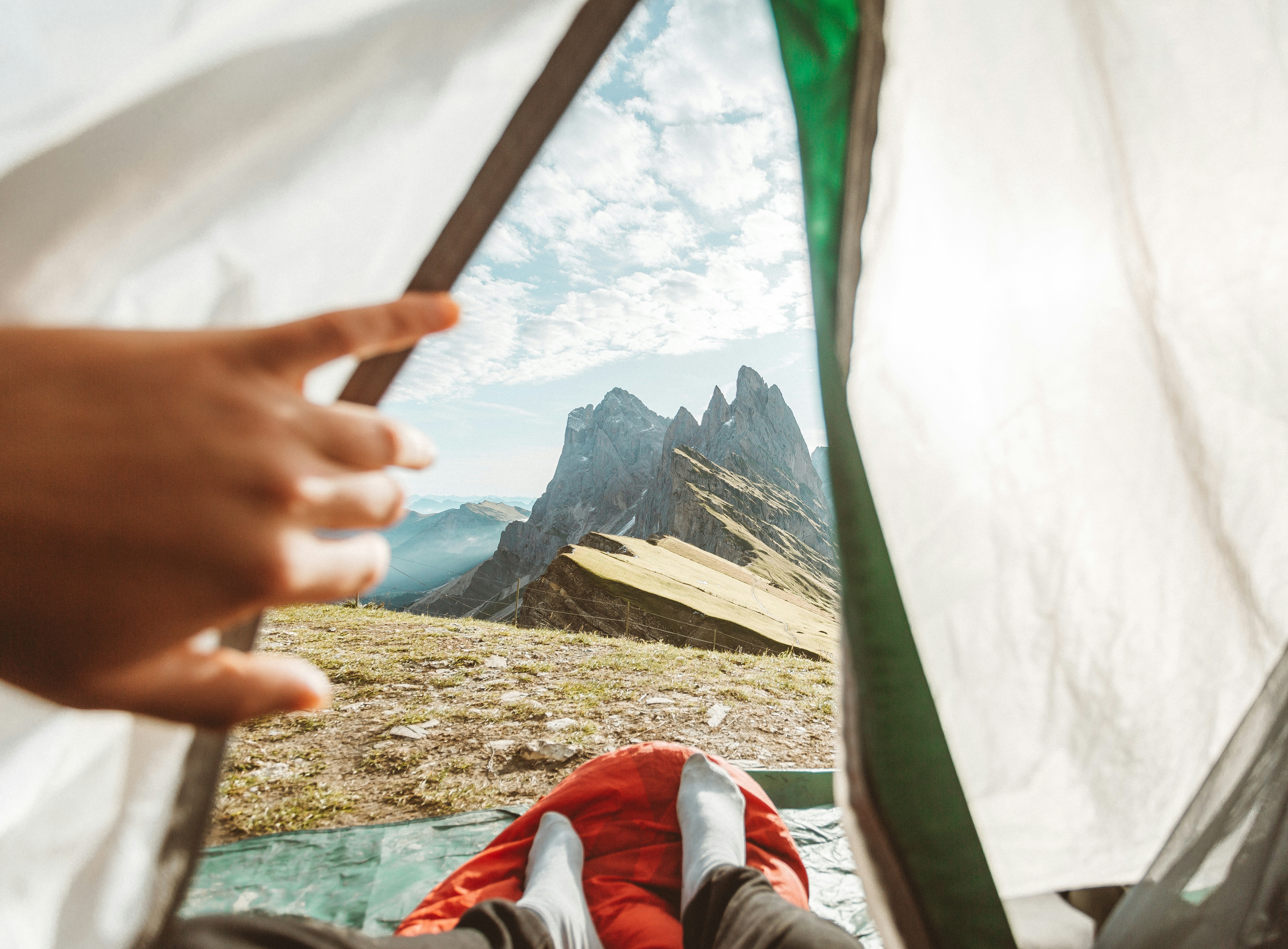 person opening tent with view of mountains