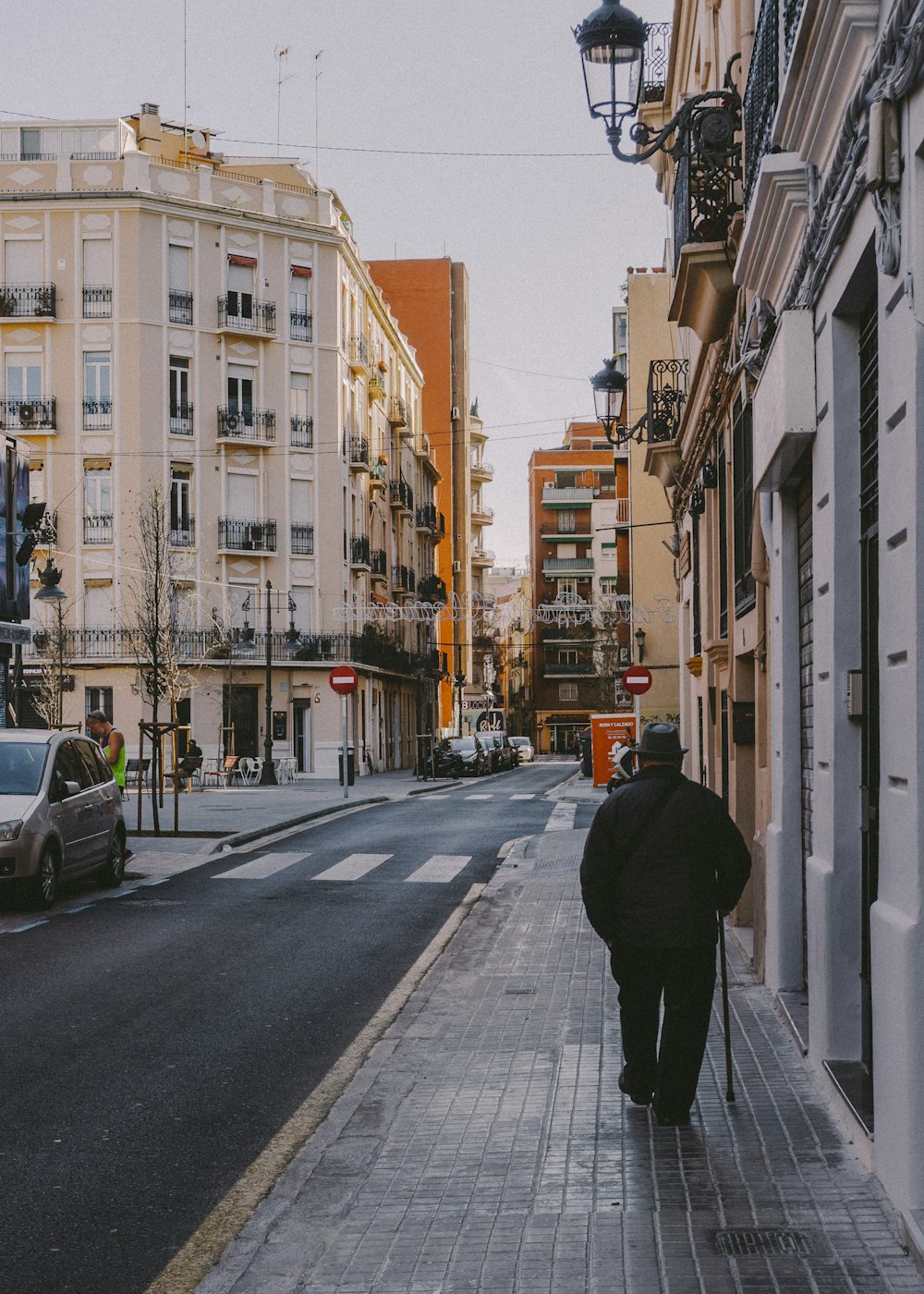 person in black coat walking on sidewalk during daytime