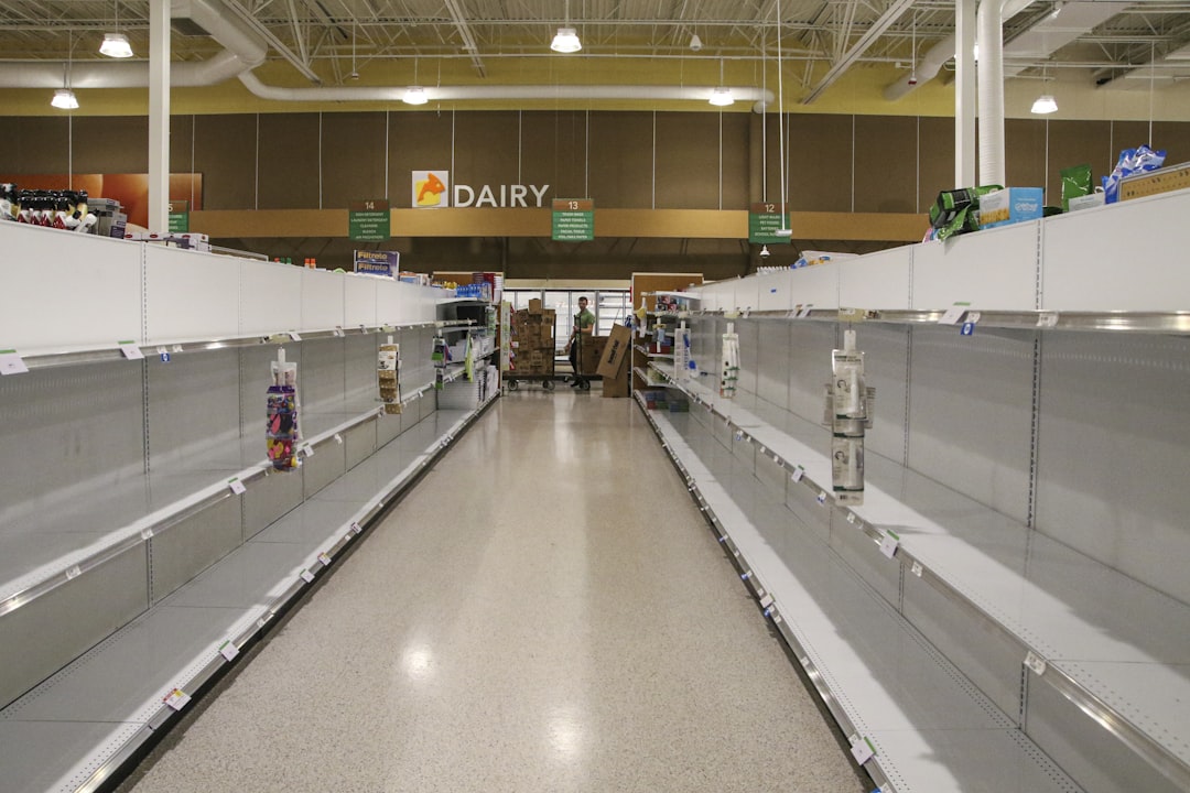 people walking inside building with escalator, Grocery stores are experiencing major hoarding of some supplies due to th