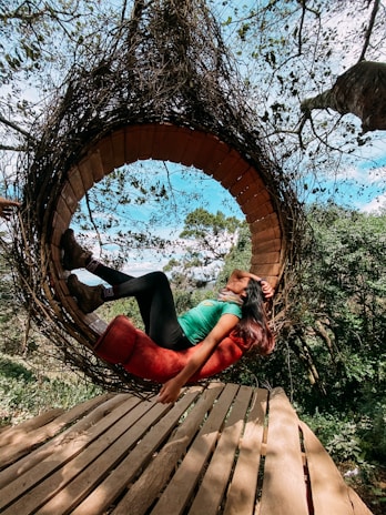 A happy customer relaxing on a patio rocking chair with a soft Swingnest cushion.