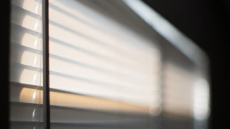 Soft morning light filtering through a nursery window, casting gentle shadows on a cozy crib.