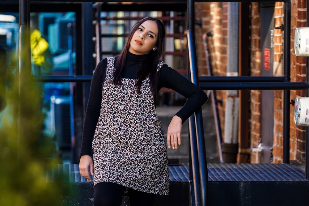 woman in black cardigan standing beside black metal railings