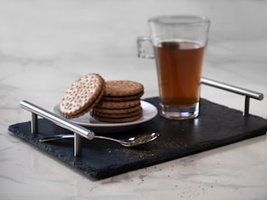 clear glass mug with brown liquid on black wooden table