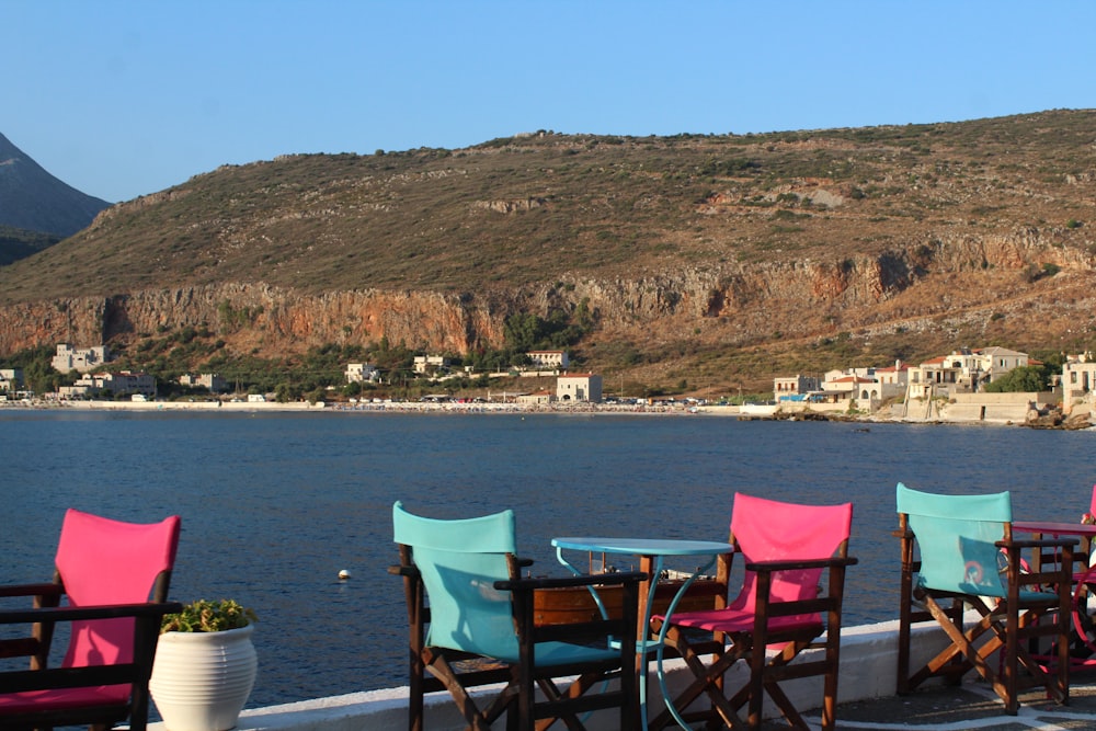 blue and brown wooden chairs near body of water during daytime