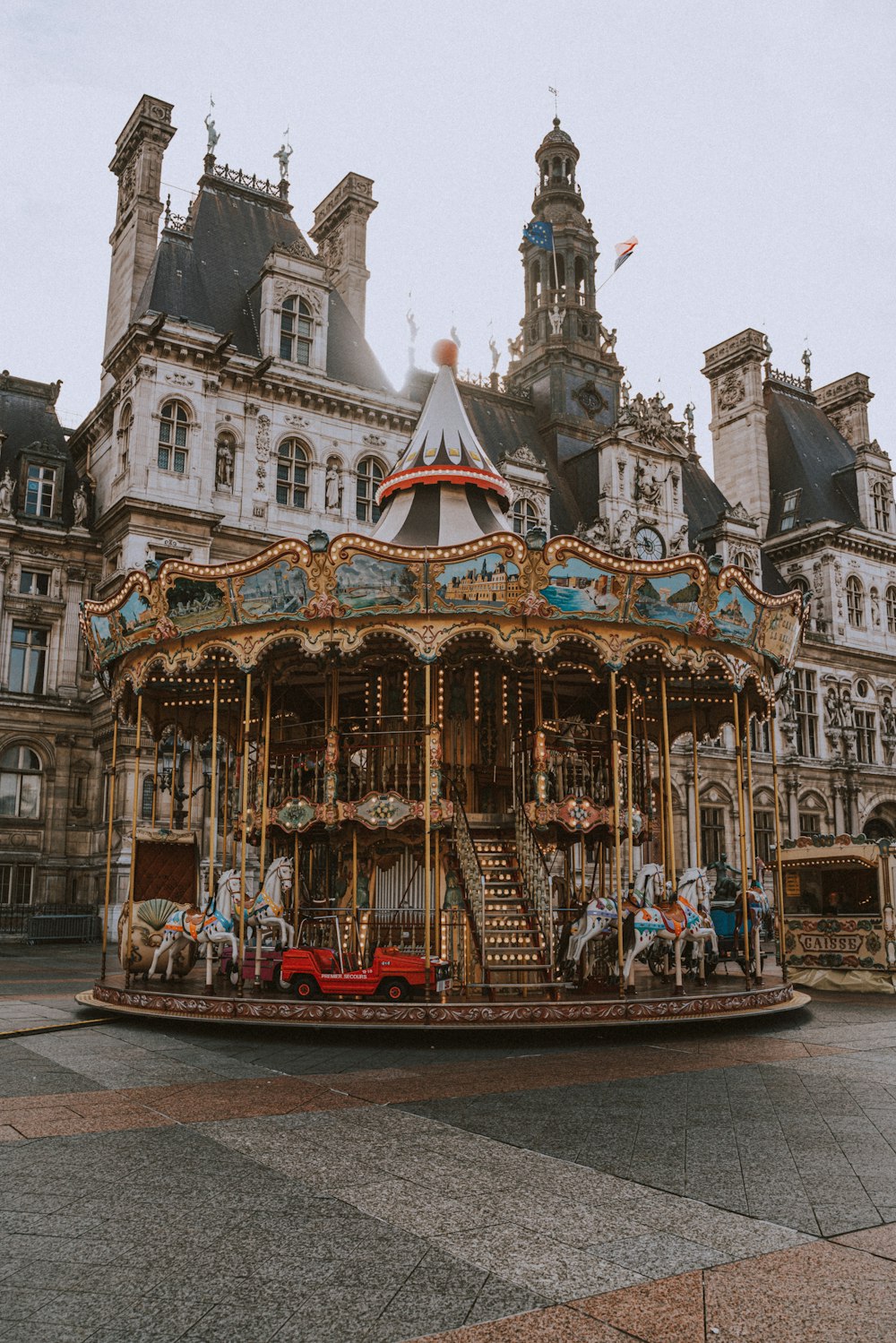 personnes roulant sur un carrousel devant un bâtiment en béton blanc pendant la journée