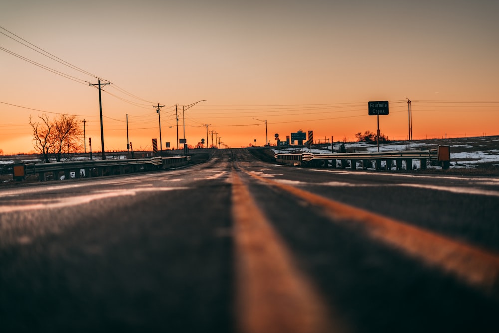 silhouette of people walking on road during sunset