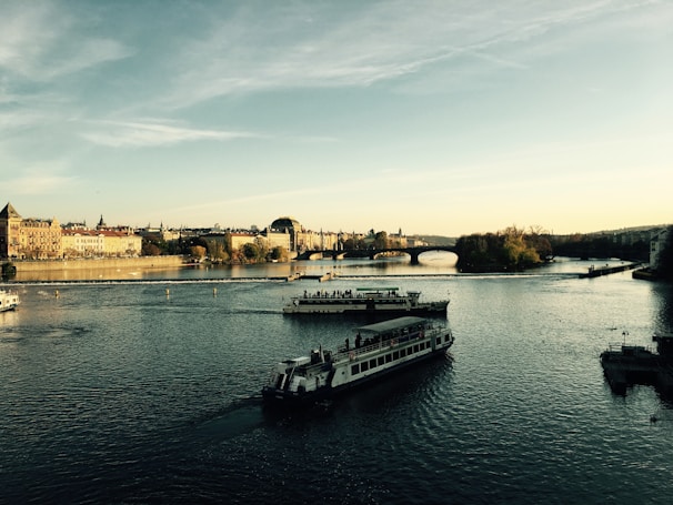 A family laughing together on a scenic European river cruise with historic castles in the background.