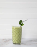 An influencer sharing a healthy smoothie recipe in a modern, clean home setting.