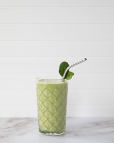 A close-up of a smoothie made with fruits and greens.