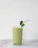 Freshly prepared green smoothie in a clear glass with droplets of condensation.