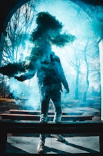 man in black jacket and pants standing on wooden bench