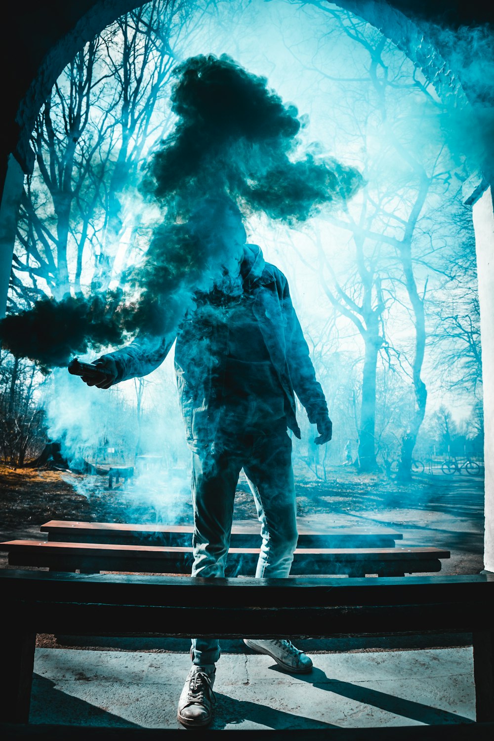 homme en veste et pantalon noirs debout sur un banc en bois