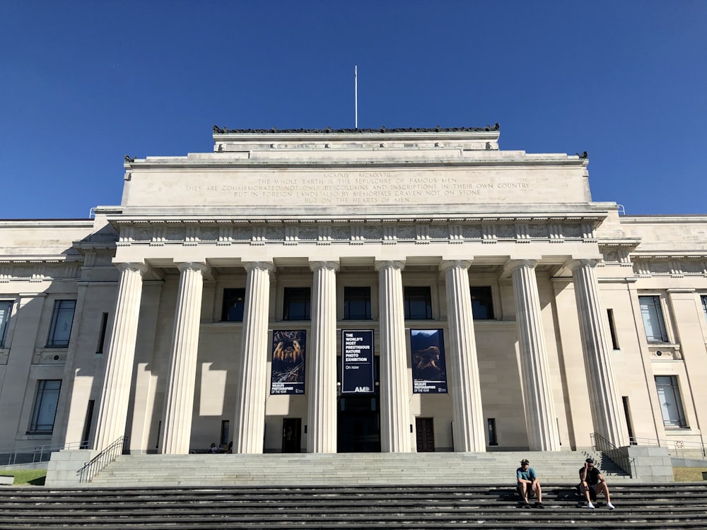 people in front of white concrete building during daytime