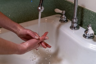 person holding stainless steel faucet