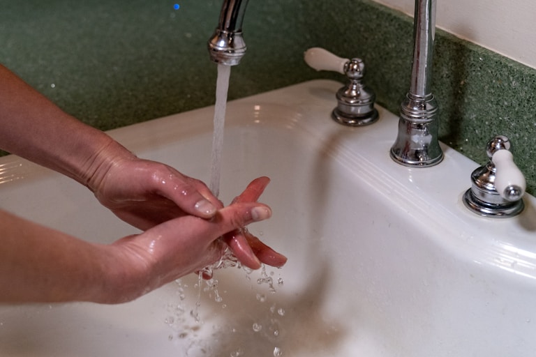 person holding stainless steel faucet