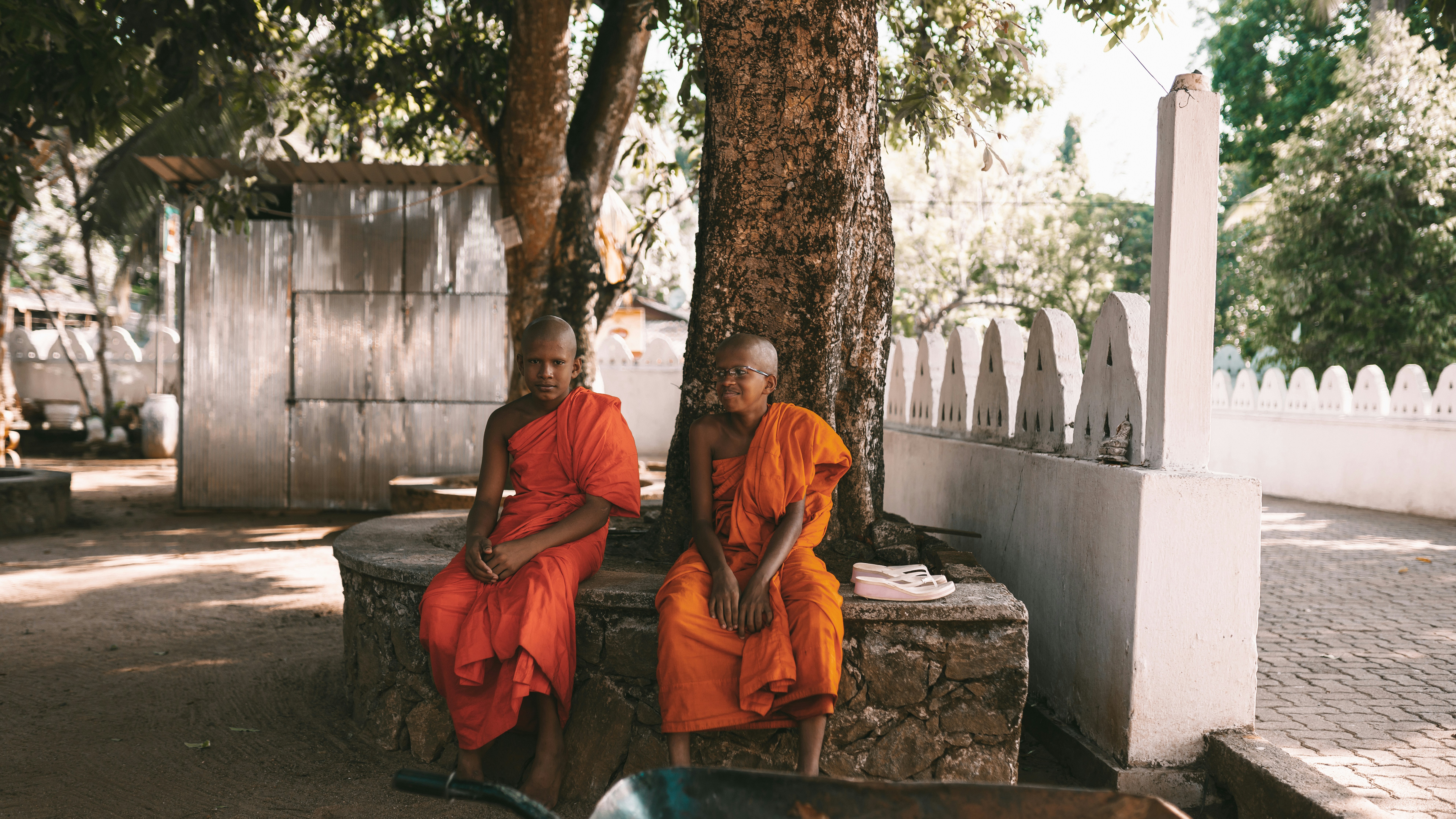 2 men sitting on brown concrete bench