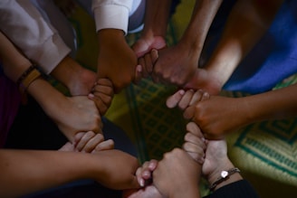VÁRIAS MÃOS JUNTAS FORMANDO UMA REDE DE APOIO MATERNO