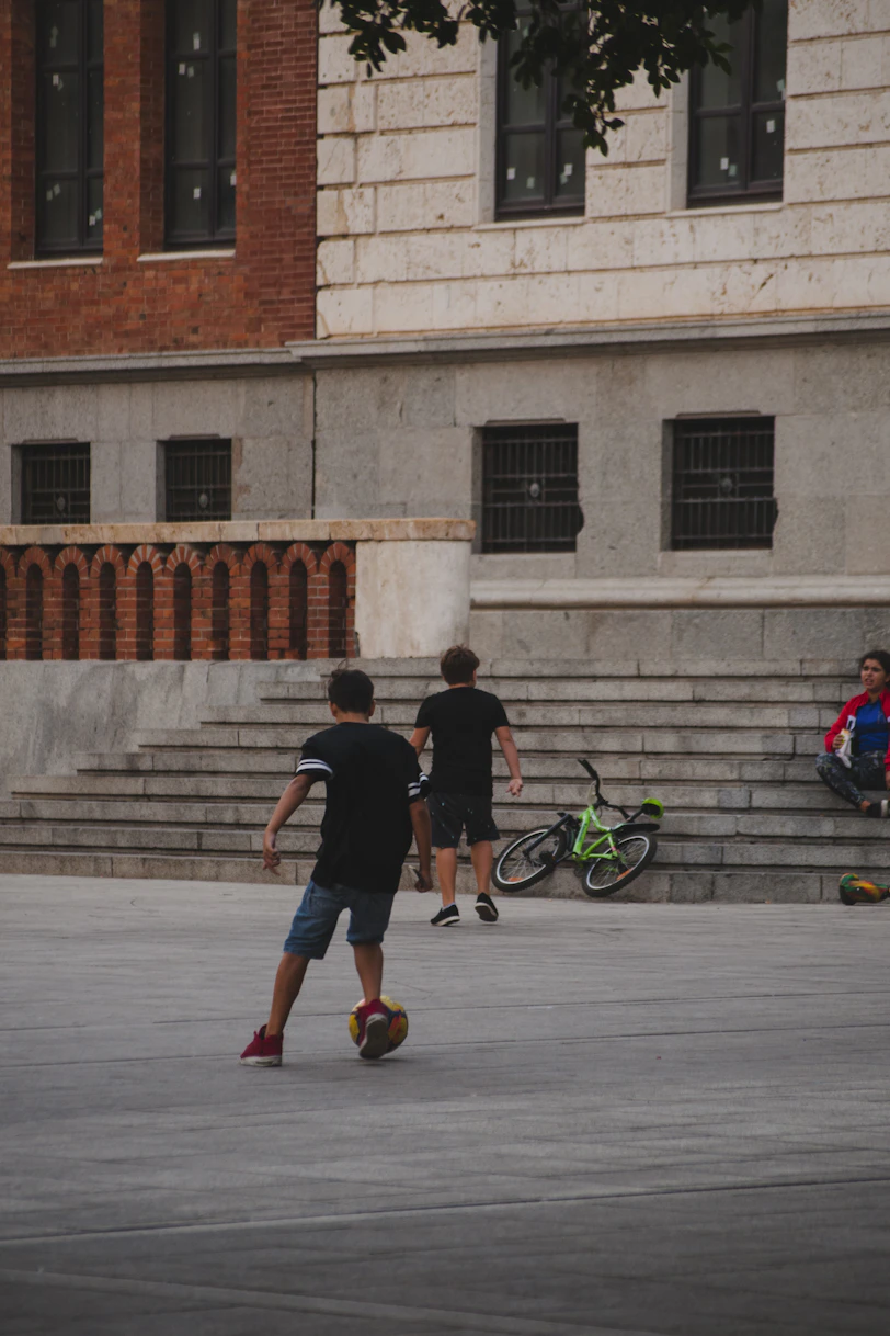 man in black t-shirt and blue shorts riding bicycle