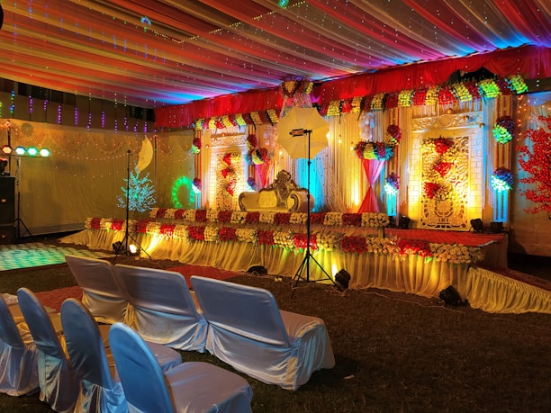 A beautifully decorated wedding stage glowing warmly under soft lights.