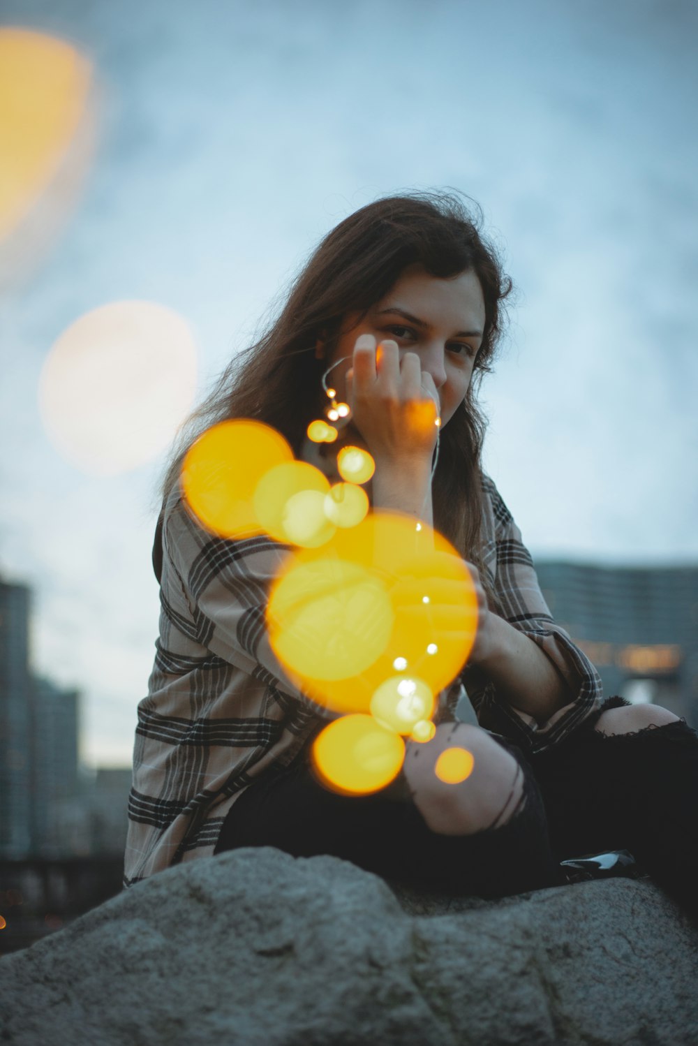 woman in black leather jacket holding yellow balloons during daytime