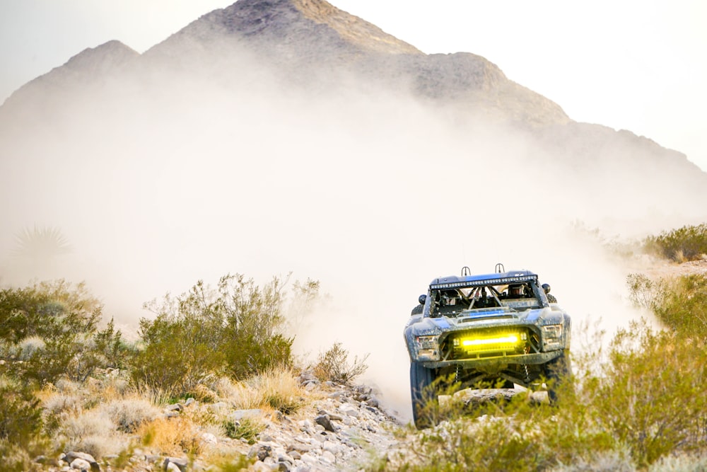 green car on green grass field near mountain during daytime