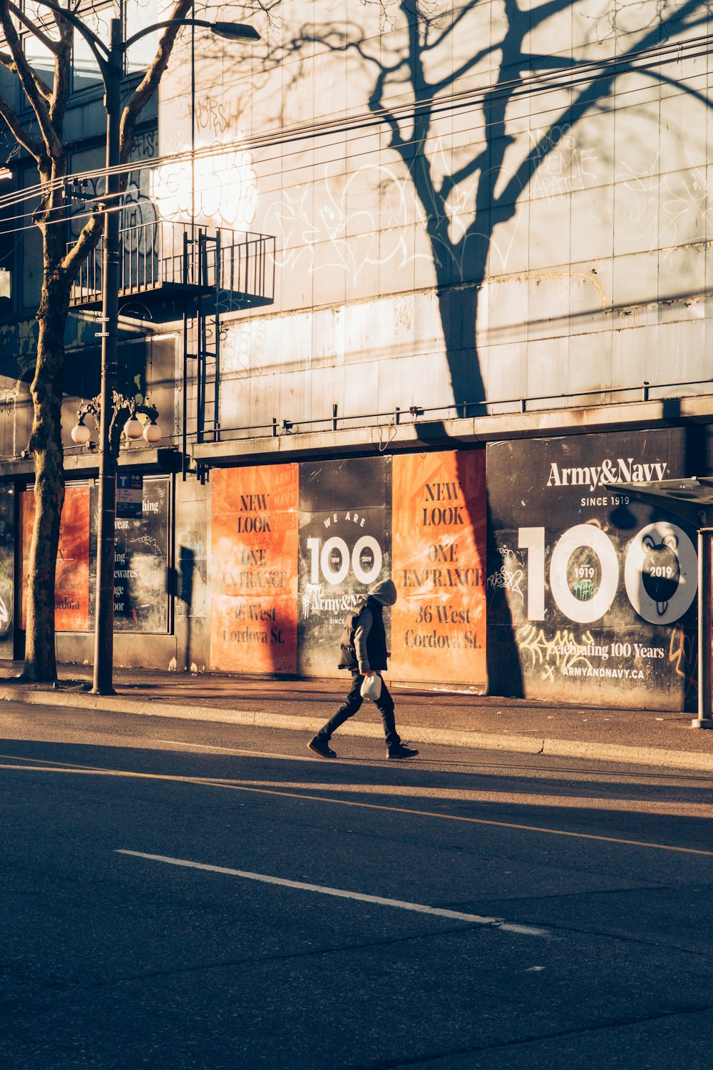 person walking on sidewalk near building during daytime