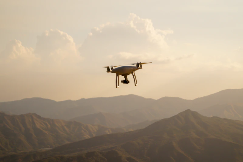 Camera drone flying over a mountain range at dusk