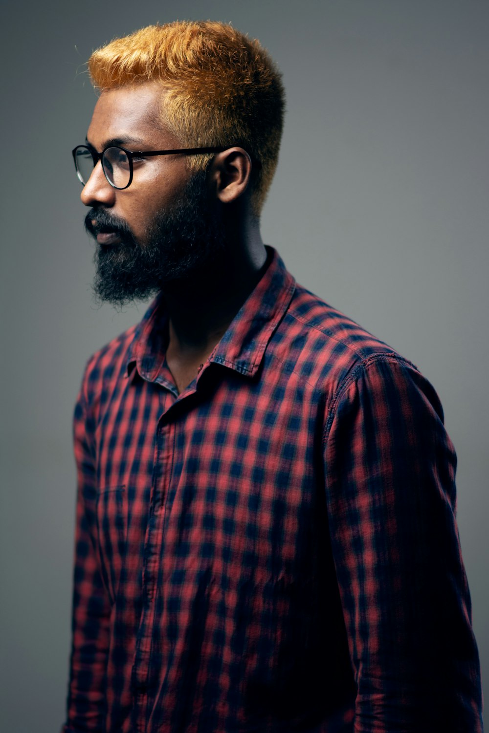 man in red and black plaid button up shirt wearing black framed eyeglasses