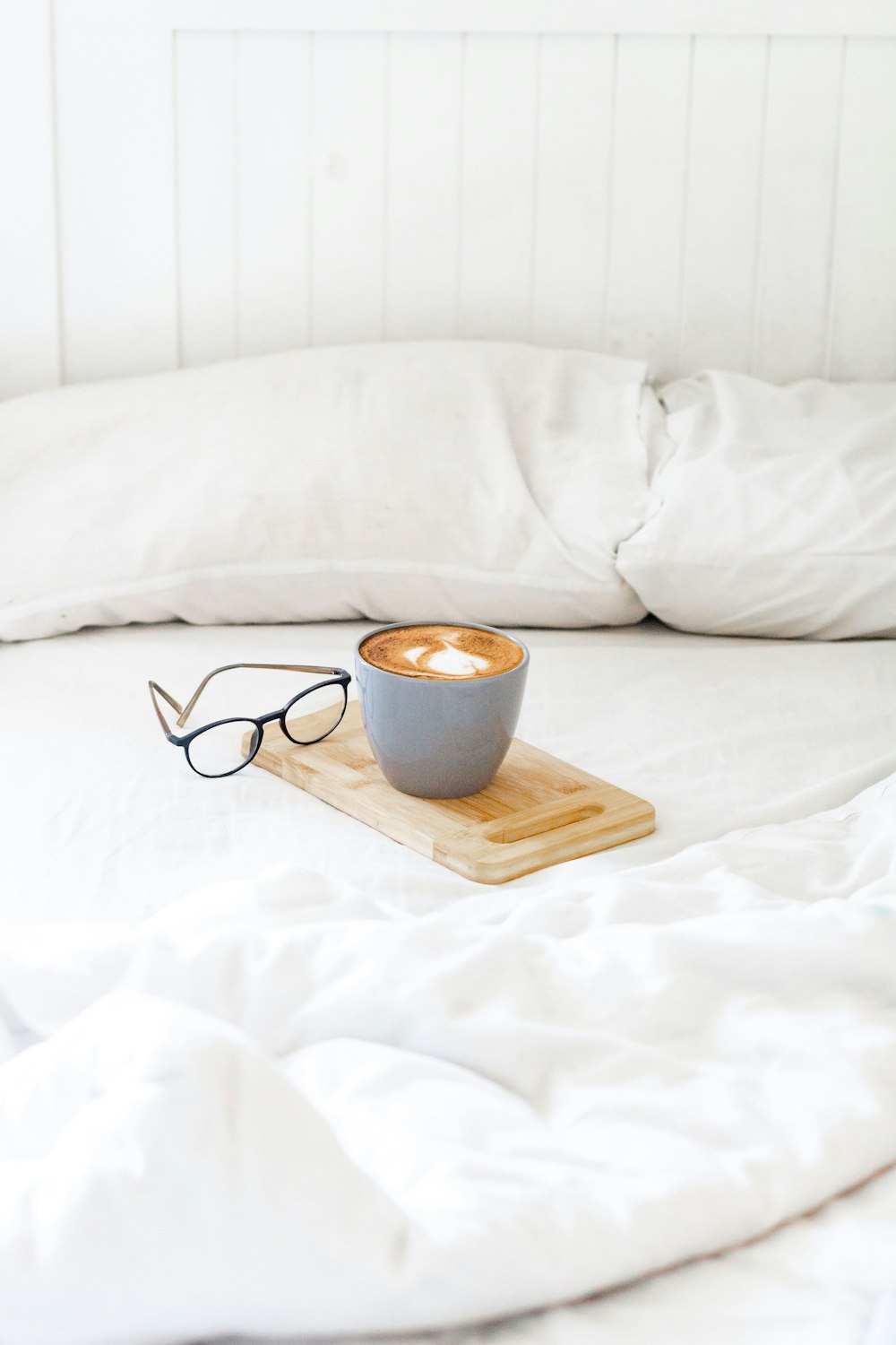 black and white ceramic mug on brown wooden chopping board