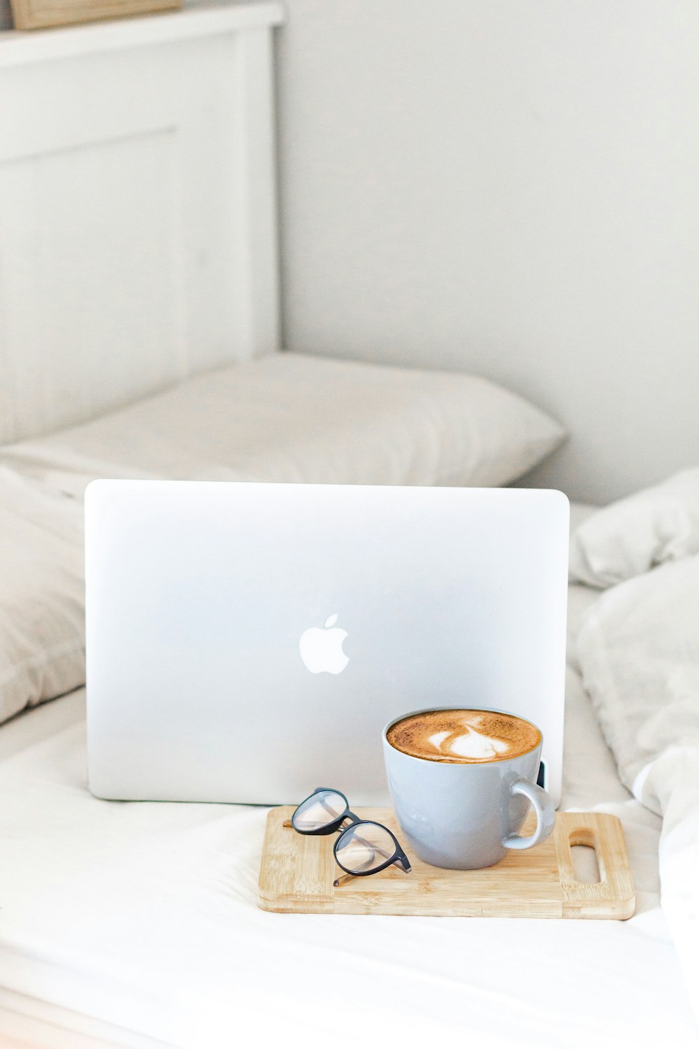 MacBook Air Beside Tazza in ceramica bianca su letto bianco