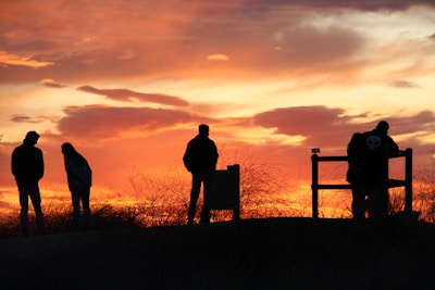 A vibrant sunset backdrop with silhouettes of happy women.
