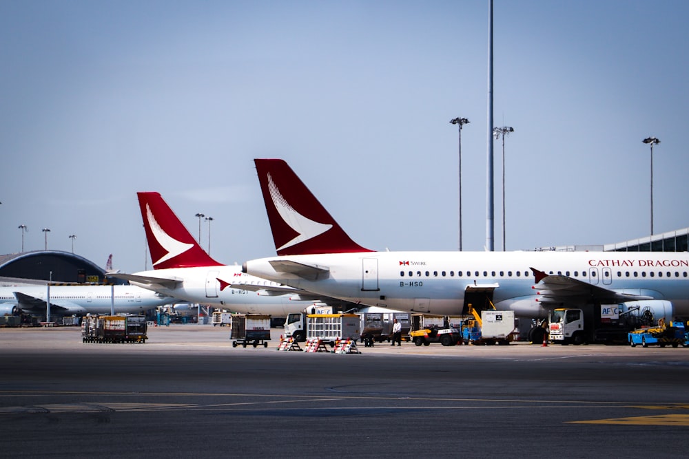 weißes und rotes Flugzeug tagsüber am Flughafen