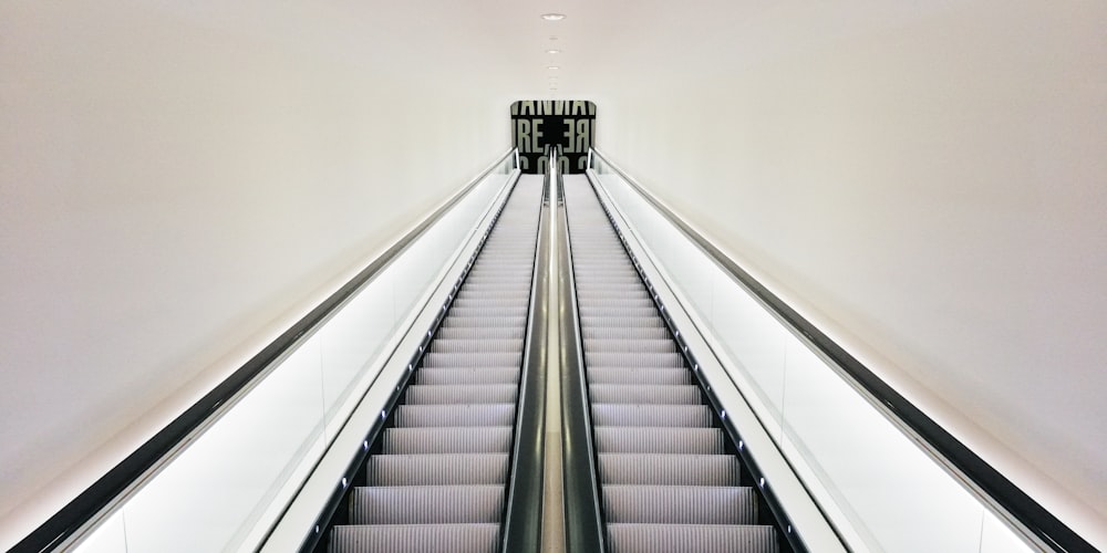 white and black escalator in white room