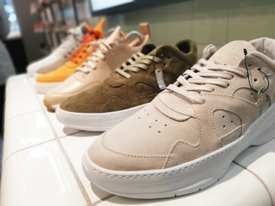 Close-up of stylish casual sneakers arranged on a warm beige textured background.