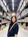woman in black long sleeve shirt standing near brown wooden shelf