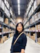 woman in black long sleeve shirt standing near brown wooden shelf