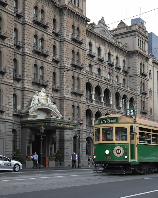 yellow and white tram on road near building during daytime in Hotel Windsor Australia