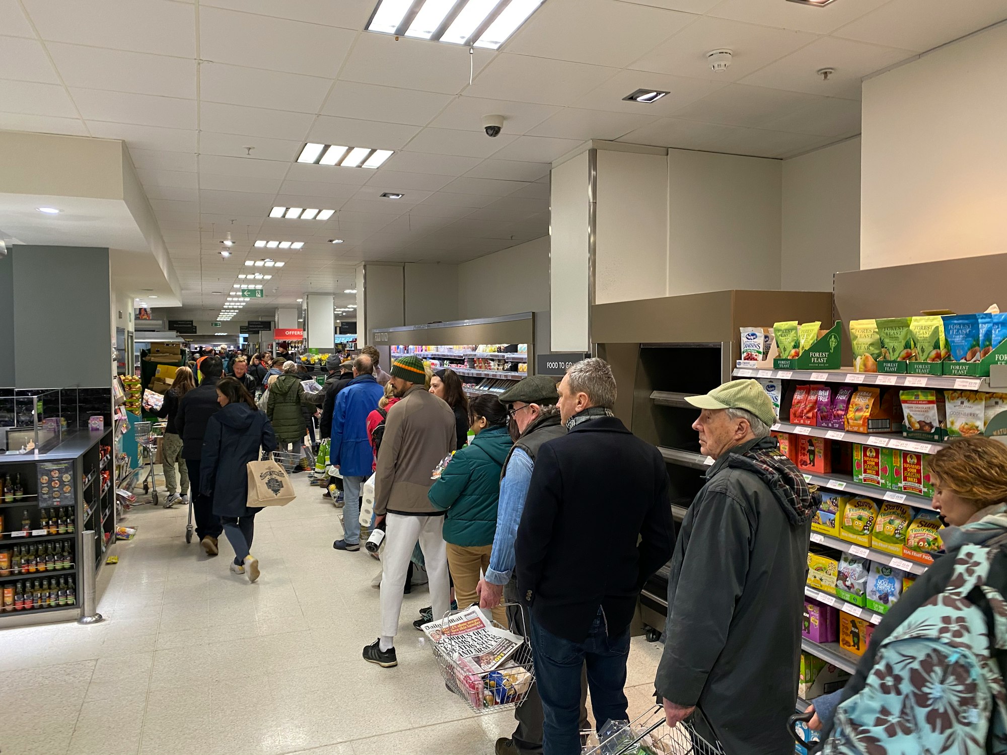 Shoppers patiently wait to pay in Waitrose, as London prepares to lockdown