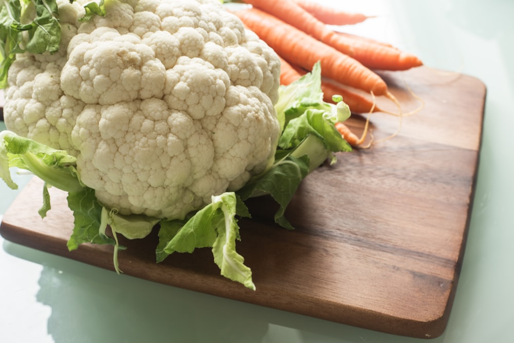 white cauliflower and carrots on brown wooden table