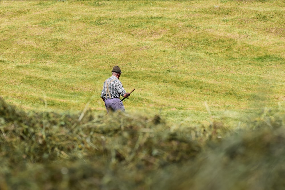 boy in white and blue plaid dress shirt and brown pants standing on green grass field