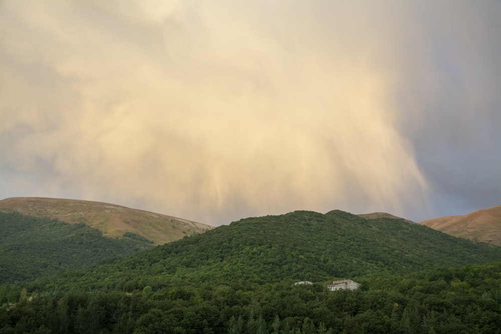 green mountain under white clouds during daytime