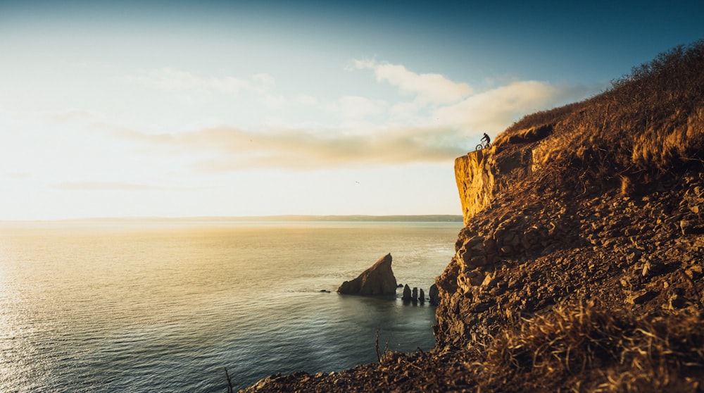 brown rock formation beside body of water during daytime