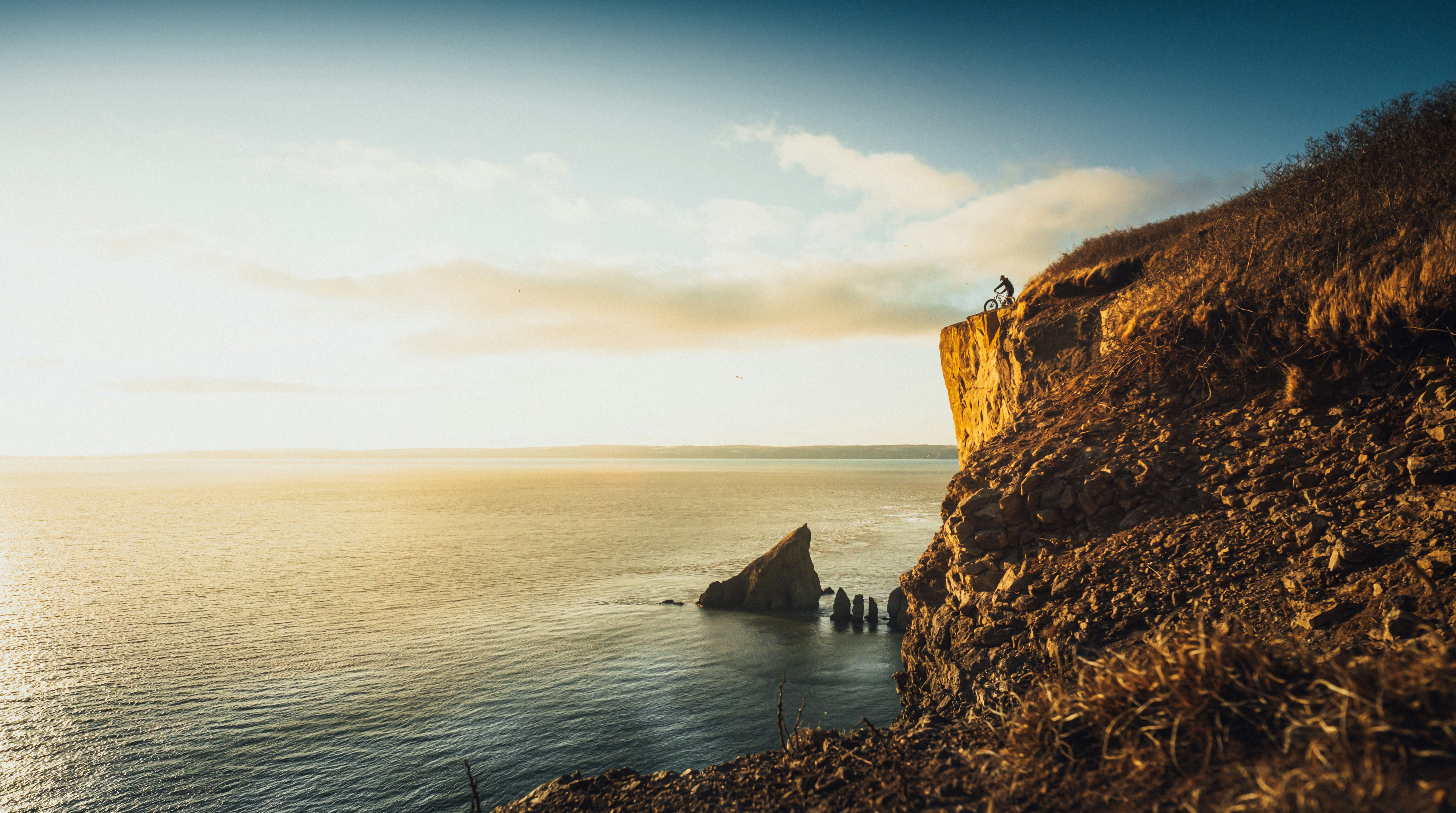 brown rock formation beside body of water during daytime